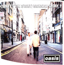 a couple of men walking down a street next to tall buildings