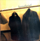 a black cat sitting next to a black dog