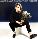 a woman holding a bunch of flowers sitting on top of a white block