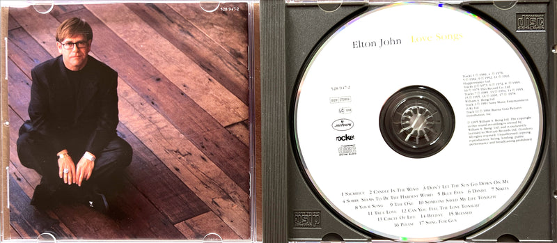 a cd with a picture of a man sitting on a wooden floor