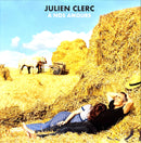 a man and a woman laying on the ground next to a pile of hay