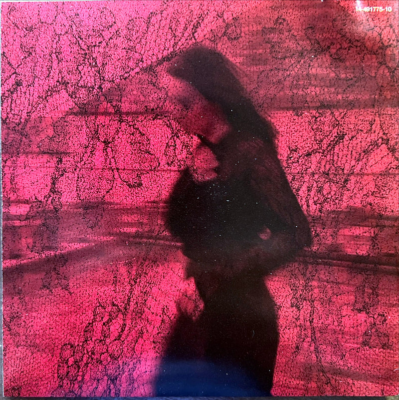 a woman standing in front of a pink wall