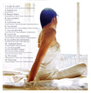 a woman sitting on top of a bed next to a window