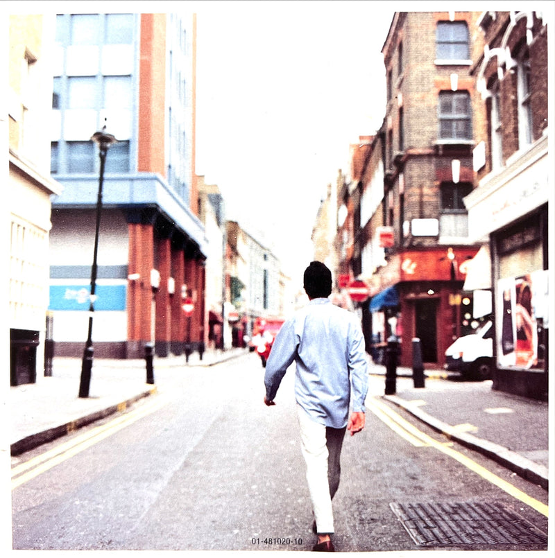 a man walking down a street in a city