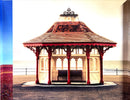 a red and white gazebo sitting on top of a sidewalk