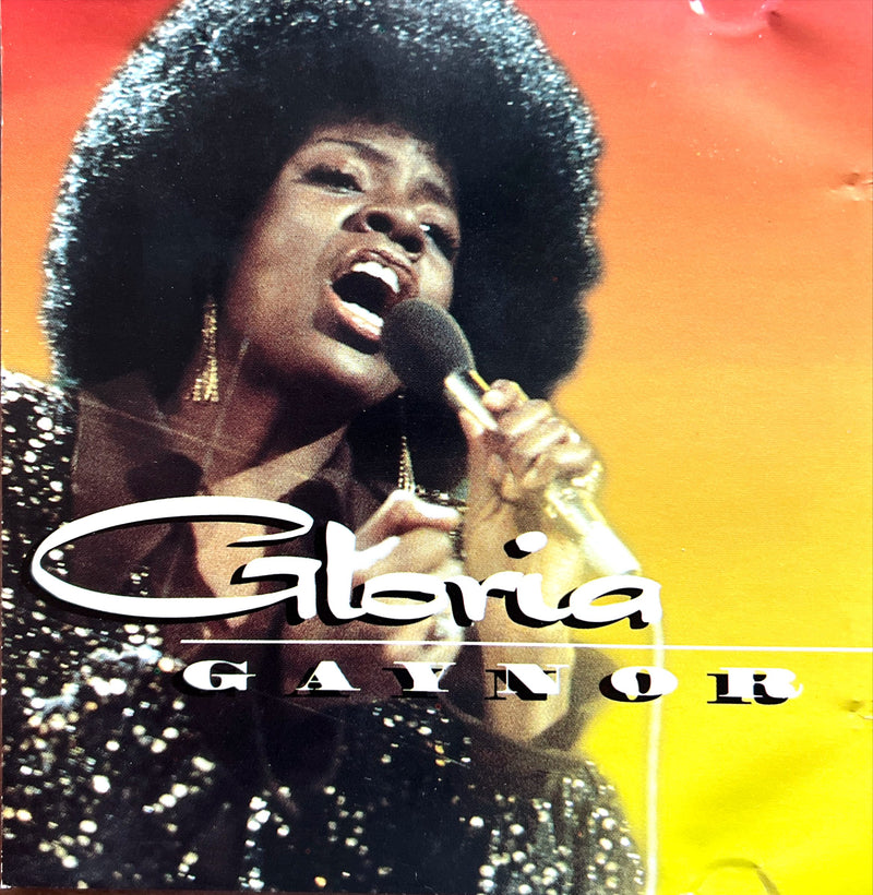 a woman singing into a microphone in front of a colorful background