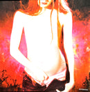 a woman with long red hair standing in front of a painting