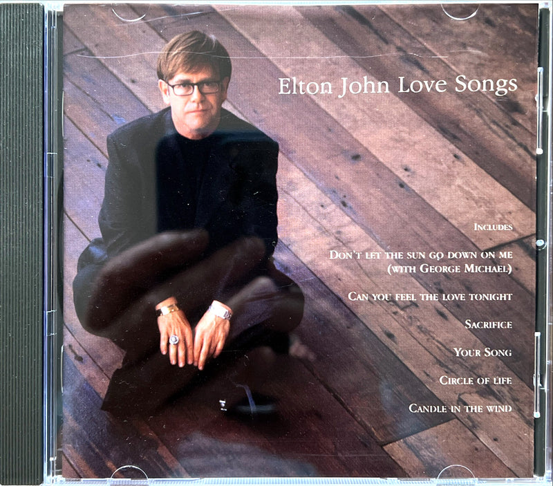 a cd cover with a man sitting on the floor