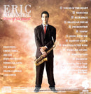 a man in a suit and tie holding a saxophone