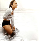 a woman in a white shirt and black shorts in the water