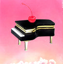 a piano with a cherry on top of it